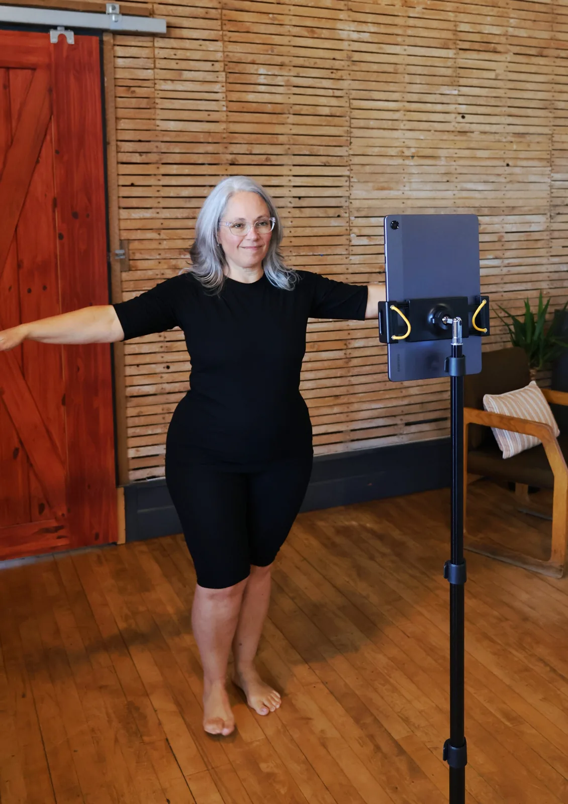 A client standing with her arms extended in front of the Fit3D scanning tablet